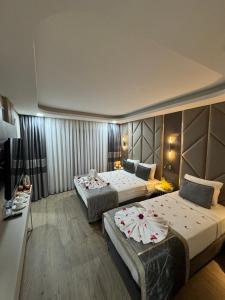 a hotel room with two beds and a television at Elysia Plus Hotel in Istanbul +33 photos