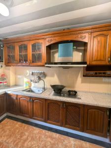 a kitchen with wooden cabinets and a sink at Xiannv Mountain House in Chongming