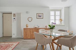 a dining room with a glass table and chairs at Apartment Maira in Chiavenna