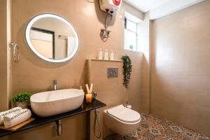 a bathroom with a sink and a toilet and a mirror at Staymaster Encanto - Serviced 2BHK in Siolim +41 photos