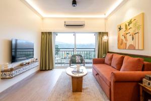 a living room with a couch and a television at Staymaster Encanto - Serviced 2BHK in Siolim