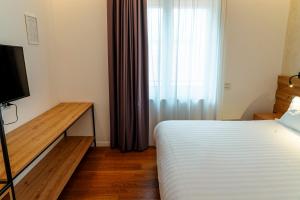 a bedroom with a bed and a tv and a window at GRANDI 32 Boutique Residence in Segrate