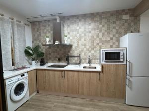 a kitchen with a white refrigerator and a sink at Almodovar alojamientos 1 in Almodóvar del Río