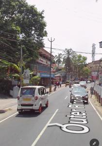 two cars are parked on a city street with a bike lane at G studio in Guruvāyūr