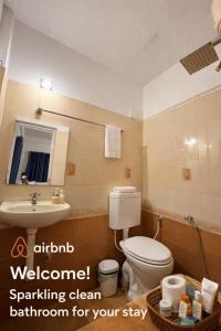 a bathroom with a toilet and a sink and a mirror at G studio in Guruvāyūr