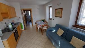 a living room with a blue couch and a kitchen at Sambor apartment in Oga