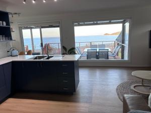 a kitchen with a view of the ocean at Five Little Ducks in Adventure Bay +22 photos