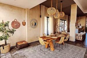 a dining room with a wooden table and chairs at Meezane Farmhouse in Bir Jedíd Saint-Hubert