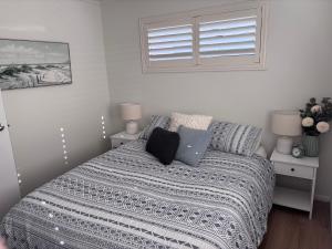 a bedroom with a bed with a laptop on it at Five Little Ducks in Adventure Bay
