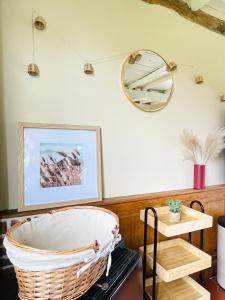 a wicker basket sitting in a room with a mirror at La Longère au Fil des Saisons in Favières