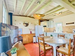a kitchen with a table and chairs in a room at La Longère au Fil des Saisons in Favières