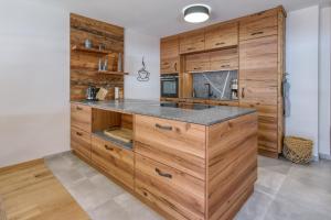 a kitchen with wooden cabinets and a counter at Chalet Loferwinkl in Reit im Winkl +24 photos