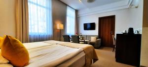a hotel room with a bed and a living room at Hotel Zamek Centrum in Szczecin