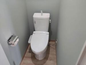 a white toilet in a bathroom with a roll of toilet paper at シーシャイン北金沢 102号室 in Aomori
