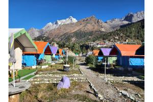 a group of colorful encampments in front of a mountain at Baspa Valley Adventure Camp in Saturang
