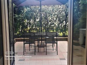 a table with chairs and an umbrella on a patio at host di Elena in Lesmo