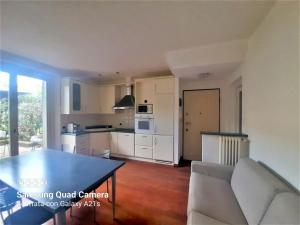 a kitchen and living room with a table and chairs at host di Elena in Lesmo