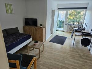 a bedroom with a bed and a television and a living room at Ferienwohnung Linden in Willich