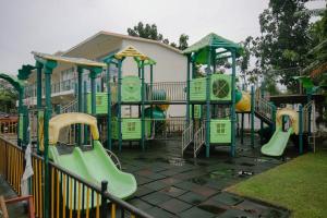 a playground with green equipment in a park at M&B Urban Haven in Suba