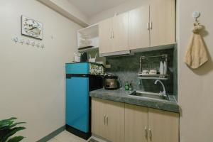 a kitchen with a blue refrigerator and a sink at M&B Urban Haven in Suba