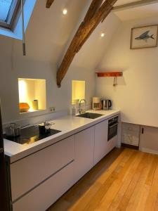 a kitchen with white cabinets and a sink at Appartement city center in Harlingen +14 photos