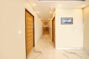 a hallway with wooden doors and a tile floor at FabHotel Rudra in Dehradun