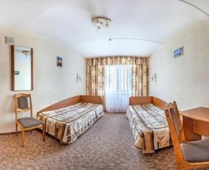 a room with two beds and a table and a desk at pokojówka,WiFi,parking P in Poznań
