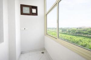 a room with a window with a view of a field at FabHotel Rudra in Dehradun