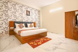 a bedroom with a bed in a room with wallpaper at FabHotel Rudra in Dehradun