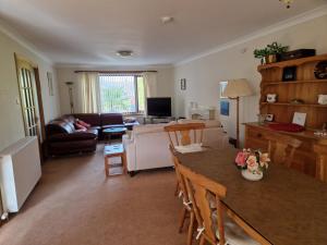 a living room with a table and a couch at Brandane in Brodick