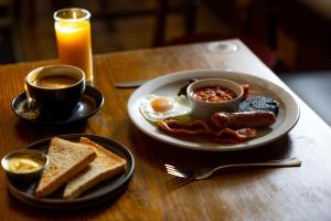 a breakfast plate of eggs bacon toast and coffee on a table at The bucks head in Church Stretton +13 photos