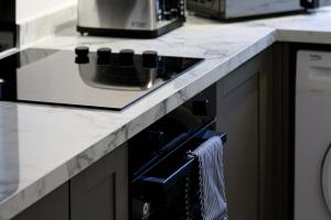 a kitchen with a counter with a stove top oven at Serviced Apartment near Prestwick Airport with Private Parking - Long Stays Available in Prestwick +11 photos