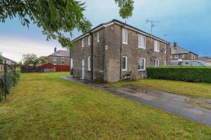 an old brick house with a grass yard at Serviced Apartment near Prestwick Airport with Private Parking - Long Stays Available in Prestwick