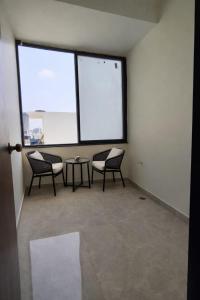 a room with three chairs and a table and windows at Orin Suites Gachibowli in Hyderabad +5 photos