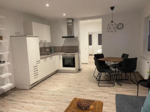 a kitchen with white appliances and a table and chairs at Meerzeit Strandhotel in Neuharlingersiel