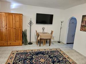 a dining room with a table and a tv on a wall at BiRo-Apartments in Zalavár