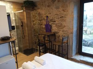 a bathroom with a shower and a table and chairs at Pensión A Lubre in Fisterra +38 photos