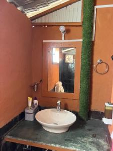 a bathroom with a sink and a mirror at Mhara Himachal in Bīr +19 photos