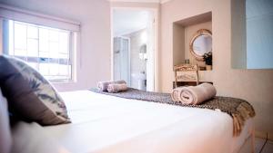 a bedroom with a bed with two towels on it at Beach Forest Lodge - Milkwood in Ballito +31 photos