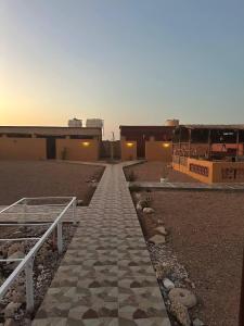 a walkway leading to a building in a desert at Holly Hills Guesthouse Ras Al Jinz in Junayz al Janūbī +16 photos
