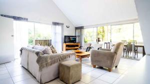 a living room with a couch and chairs and a table at Beach Forest Lodge - Milkwood in Ballito