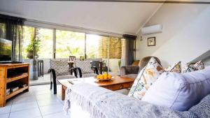 a living room with a couch and a table at Beach Forest Lodge - Milkwood in Ballito
