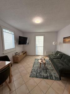 a living room with a green couch and a table at Wittower Heide 40-3 in Glowe