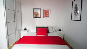 a bedroom with a red pillow on a white bed at Casita Las Lajas in El Paso