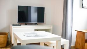 a living room with a tv and a white table at Casita Las Lajas in El Paso