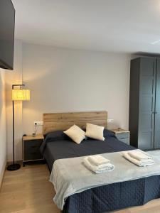 a bedroom with a bed with two towels on it at Apartamento exclusivo Muralla de Lugo 1.1 in Lugo