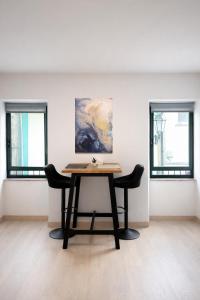 a table in a room with two windows at Apartamento exclusivo Muralla de Lugo 1.1 in Lugo