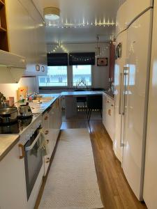 a kitchen with white appliances and a kitchen rug at Big Room in shared apartment in Kungälv