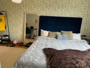 a bedroom with a large bed with a blue headboard at Big Room in shared apartment in Kungälv