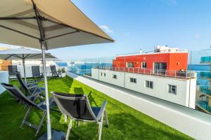 a balcony with chairs and an umbrella on a building at URBANSEA Atlanta in Las Palmas de Gran Canaria